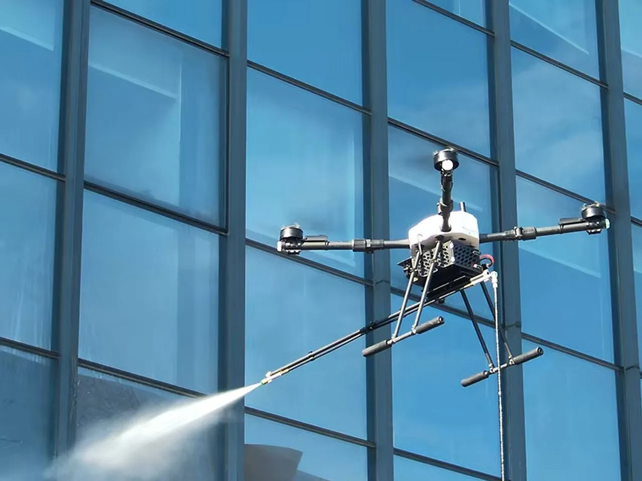 A drone cleaning the glass facade of a high-rise building
