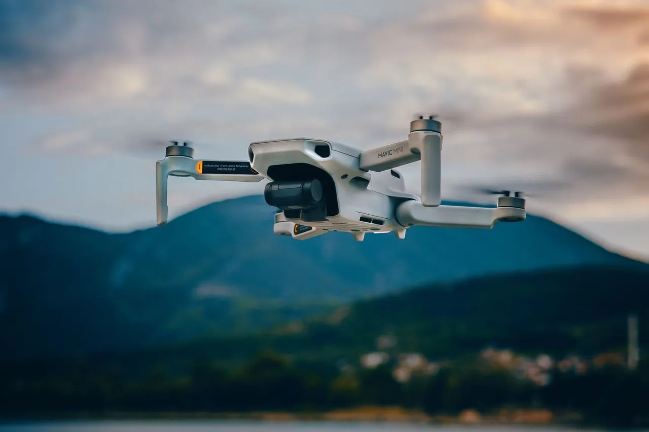 A camera drone flying over a landscape at dusk